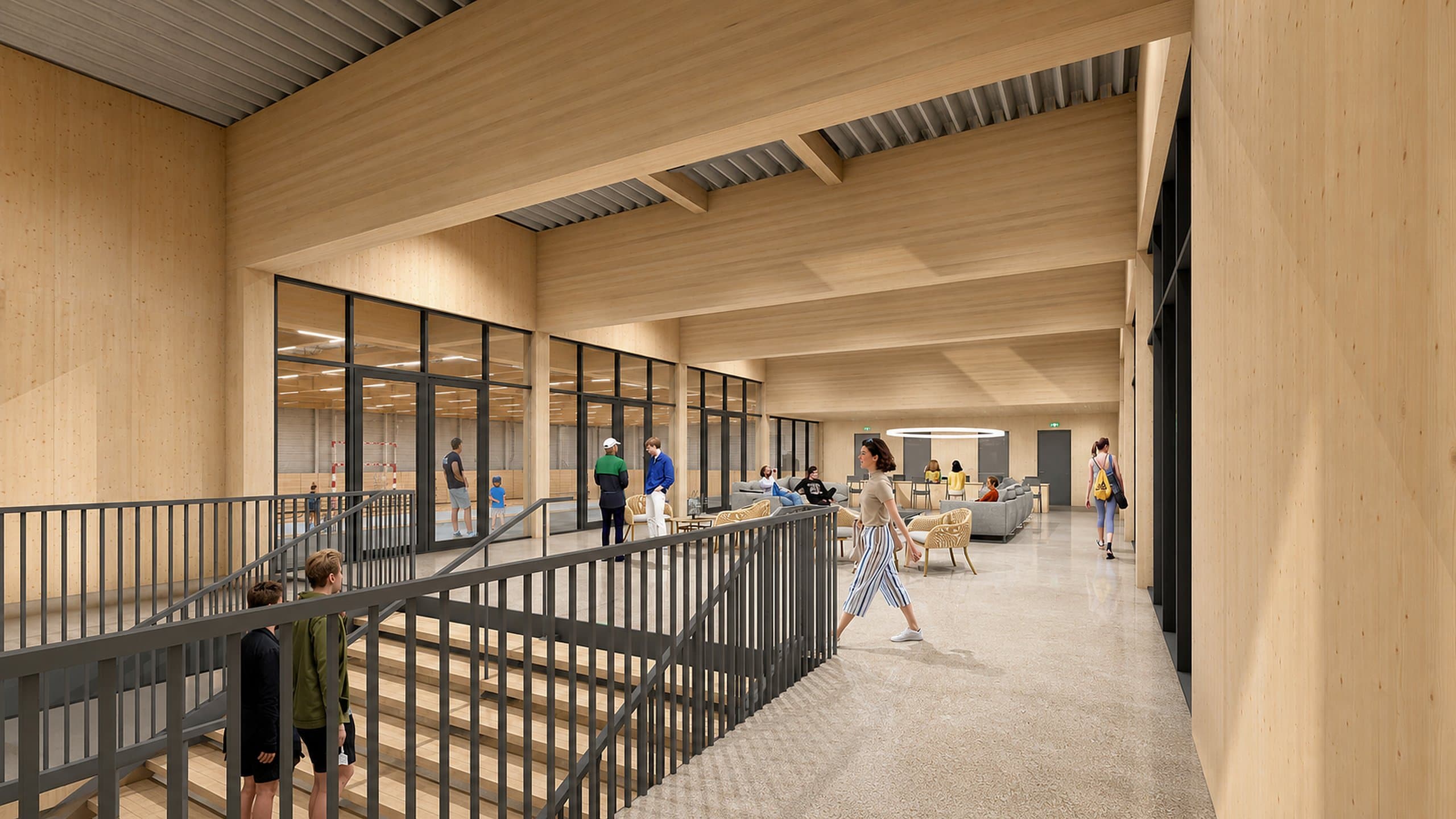 Houten foyer op de verdieping met loungezitjes en zicht door de glazen wand op de sporthal