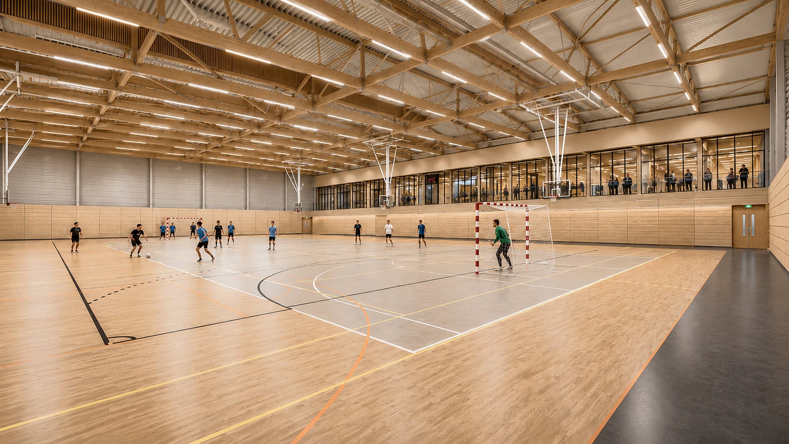 De grote sporthal met houten spanten, zaalvoetballers en toeschouwers achter de glazen wand van de foyer