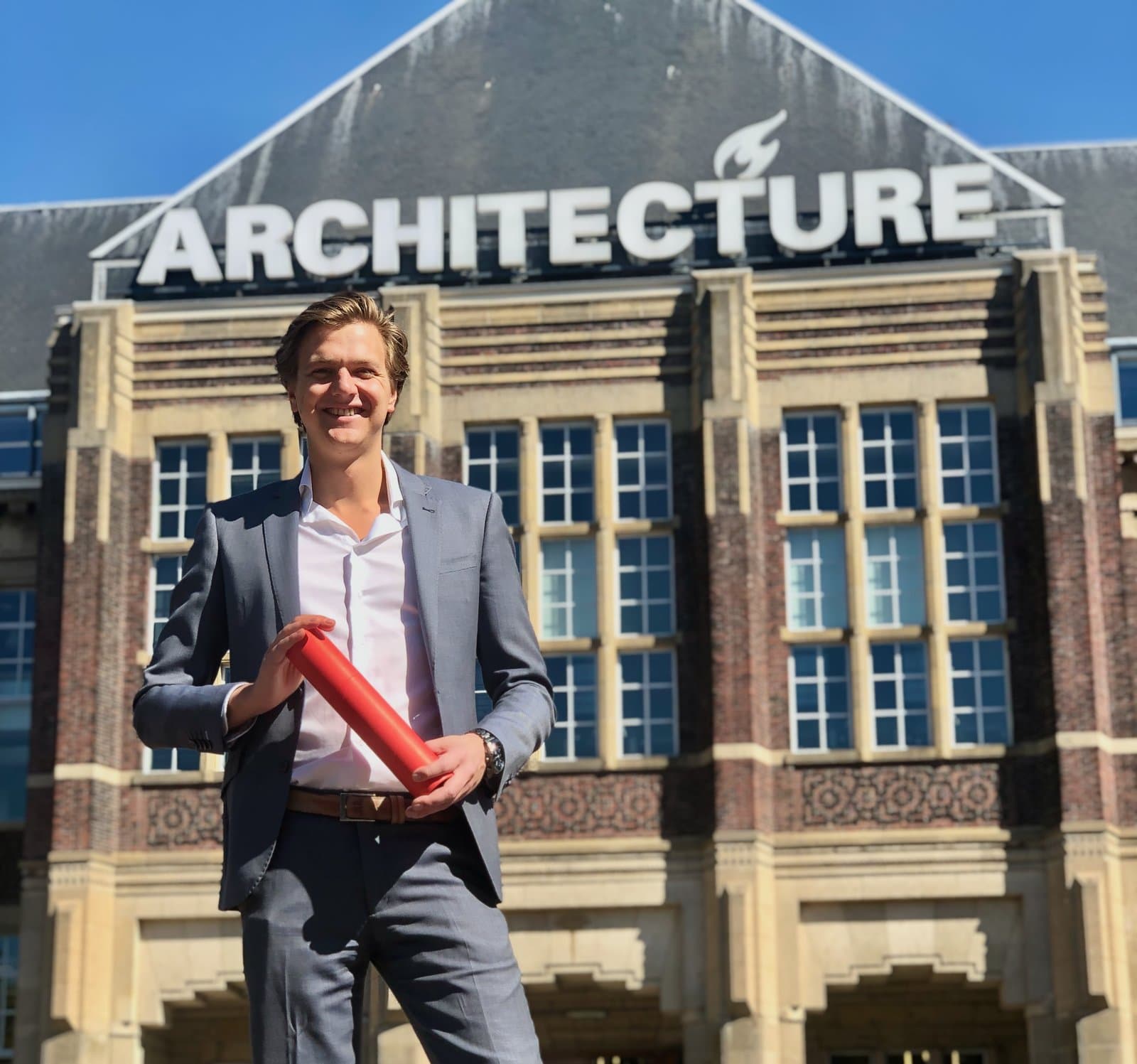 Berend Schenk met diplomakoker voor het Architecture-gebouw van de TU Delft